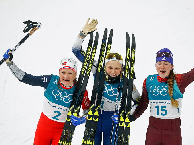 Maiken Caspersen Falla, Stina Nilsson og Yulia Belorukova jubler over medalje i OL-sprinten. Foto: REUTERS/Kai Pfaffenbach